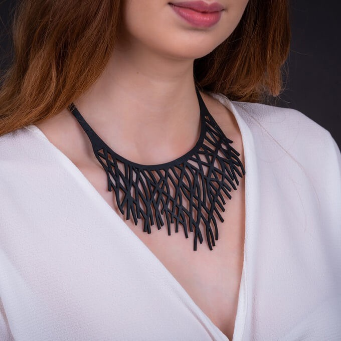 Model wearing a necklace to style a dress in a different way