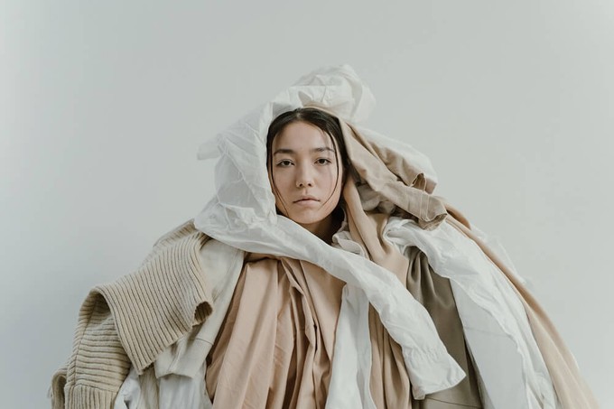 Consumer in a pile of fast fashion clothes