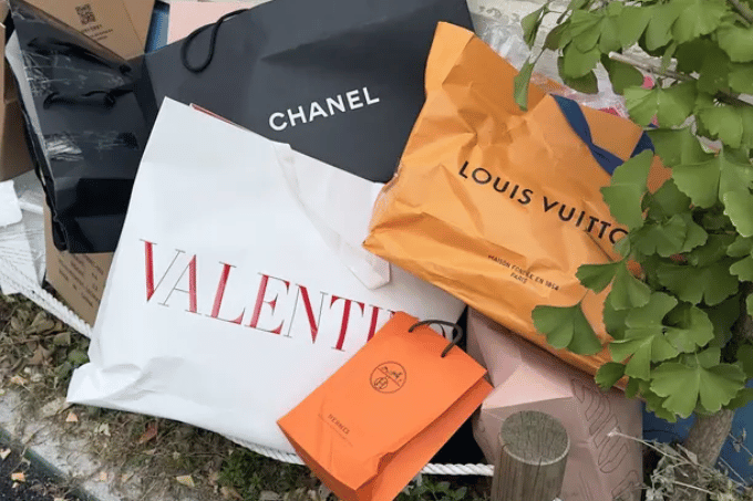 A pile of clothes shopping bag to show that you can't love both style and the environment if you buy into overconsumption